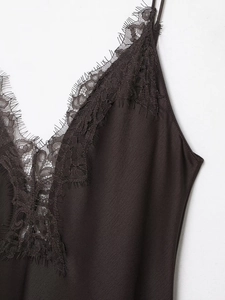 Makro-Detail des V-Ausschnitts mit zarter Wimpernspitze und schwarzem Satin-Stoff