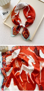 Detail of red silk scarf showing animal print and blue vintage patterns on smooth fabric