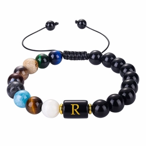 Detail of multi-color natural stone beads bracelet with a golden letter R engraving