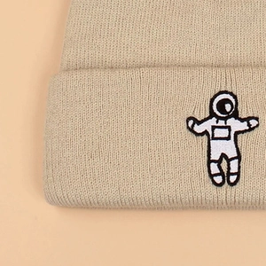 Winter beige knitted beanie with a detailed astronaut cartoon embroidery patch