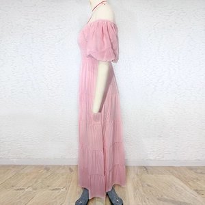Detail of pink off-shoulder maxi dress with tiered cake-style skirt and puff sleeves