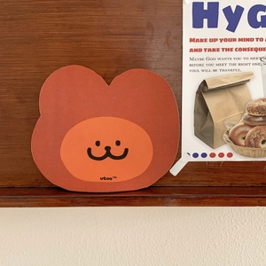 Close-up of cute bear-shaped mouse pad with smiling face on a wooden background