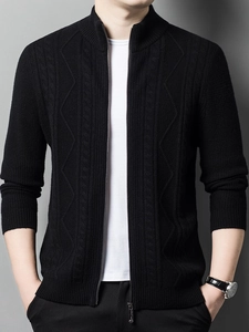 Close-up of black knitted cardigan showing geometric texture and zipper details