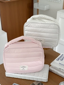 Quilted nylon portable makeup bag with horizontal stripes and sturdy handle for travel