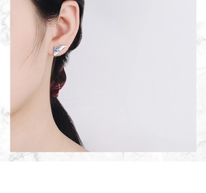 Close-up of blue gradient enamel butterfly earrings on model with marble background