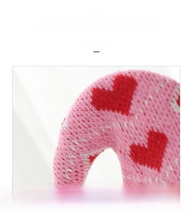 Primo piano del tessuto a maglia rosa con cuori rossi per la decorazione dello gnomo di San Valentino