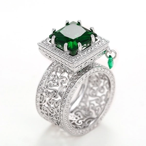 Detail view of emerald cut green gemstone ring with filigree band and zircon accents