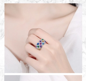 Detail of silver-finish wide band ring set with colorful round zircon stones on model hand