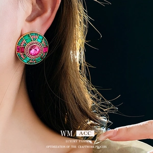 Orecchini rotondi vintage in oro con cristalli rosa e verdi indossati da una modella di lusso