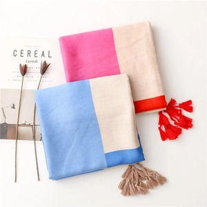 Detailed overhead shot of minimalist cotton linen shawls with fringe and contrast colors