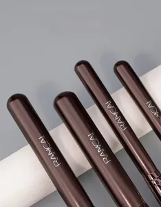 Detailed macro view of professional wooden makeup brush handles with silver logo engraving