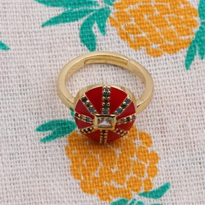 Macro shot of gold plated copper ring with red enamel and colorful zircon inlay detail