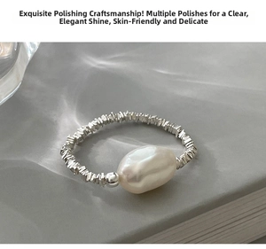 Detailed macro view of an irregular baroque pearl on a silver textured elastic band