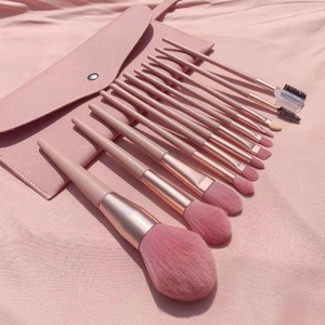 Flat lay of 10-piece pink marble makeup brush set with rose gold ferrules and PU travel bag