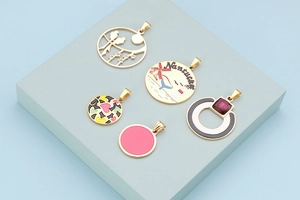 Macro shot of gold-plated geometric pendants with colorful enamel inlay and crystal details