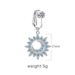 Détail du clip de nombril argenté avec pendentif soleil lune et pierres bleues claires