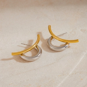 Two-tone C-shape stud earrings in gold and silver stainless steel on stone background