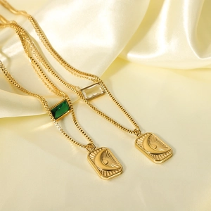 Gold layered sun and moon pendant necklace with green and clear zircon gemstones