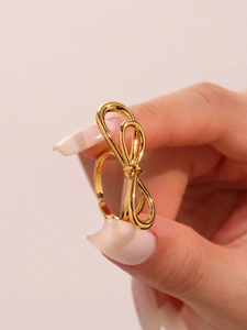 Detailed view of polished golden bow ring with adjustable open band for women