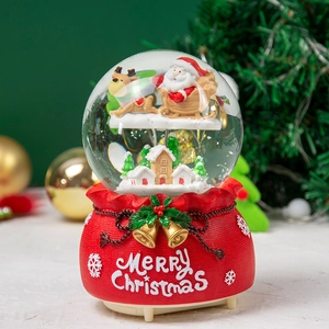 Macro detail of Christmas snow globe featuring Santa and sleigh on festive gift bag base