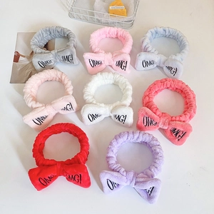Multiple colors of soft plush bow headbands with OMG! embroidery for face washing