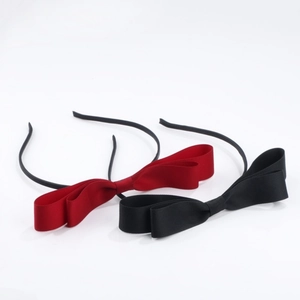 Detail view of two bow headbands in classic black and deep wine red satin fabric
