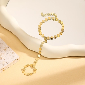 Detailed shot of golden disk finger chain bracelet with adjustable lobster clasp closure