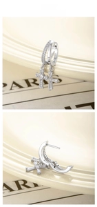 Detail of silver cross hoop earrings with heart-shaped zircon and pave crystals