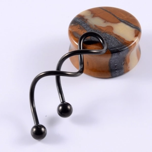 Detail of a black metal spiral ear hanger and a marbled stone ear plug on white background