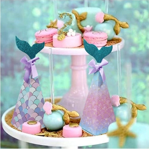 Detail view of mermaid party favor boxes with glitter fin and ribbon bow decoration