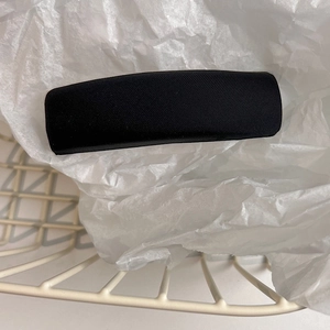 Detailed top view of black satin fabric headband on white mesh basket with aesthetic setup