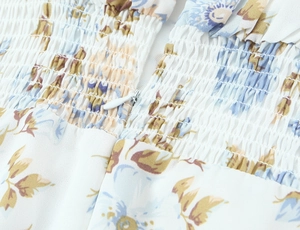Detail eines Blumen-Chiffonkleids mit elastischem Smok und weißem unsichtbarem Reißverschluss