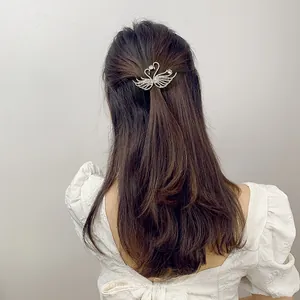 Detailed view of silver rhinestone double swan hair clip worn on long brunette hair