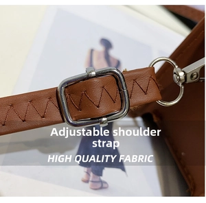 Detail of brown PU leather adjustable shoulder strap with silver buckle and chevron stitching