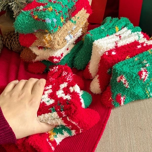 Detailed texture of thick red and green coral fleece Christmas socks with festive pine cones