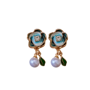 Elegant gold-plated flower earrings with blue enamel, pearls, and green leaf charms
