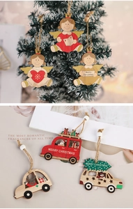 Close-up of wooden Christmas tree ornaments featuring hand-painted angel and car designs