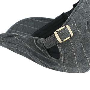Detailed side view of cotton striped beret with an adjustable bronze metal buckle