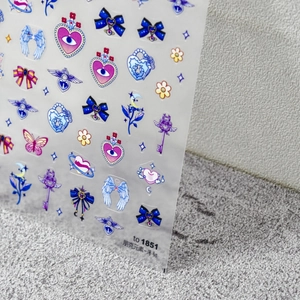 Détail de stickers à ongles style punk avec nœuds bleus cœurs et motifs de papillons
