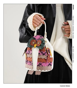 Detail of owl-shaped shoulder bag featuring textured snake-skin pattern patches