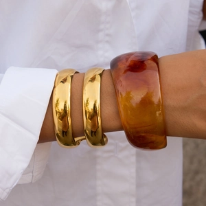 18K gold plated stainless steel layered cuff bracelet with amber resin accent on wrist