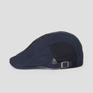 Detail view of navy cotton ivy cap featuring diamond quilting and bronze side buckles