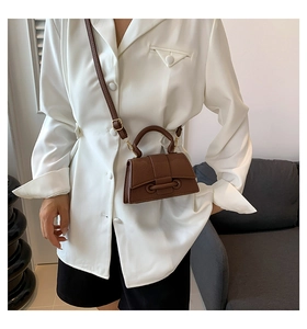 Detailed shot of brown litchi grain PU leather handbag with elegant ring buckle hardware