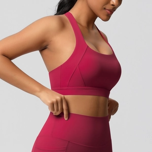 Detail van high-support sportbeha en high-waist legging in een dieprode yogaset
