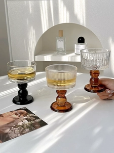 Artistic glassware with ball base and ribbed texture in amber and black finishes