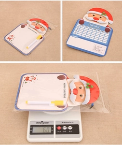 Detail view of Santa Claus reusable time table board and marker weighing 60g on a scale