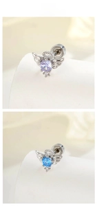 Macro detail of angel wing cartilage studs with purple and blue zircon stones