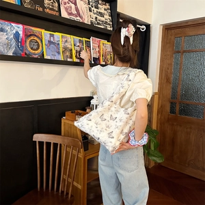 Close-up of white canvas tote bag featuring detailed butterfly print and durable fabric
