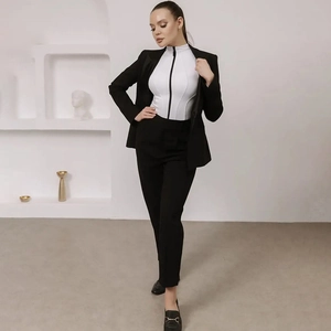 Close-up of white slim-fit bodysuit with zipper collar under a black tailored blazer jacket