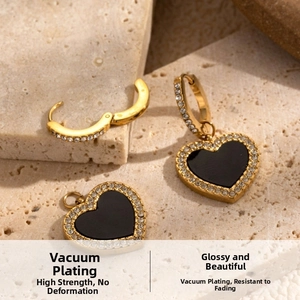 Détail macro de boucles d'oreilles cœur doré avec incrustations noires et zircons